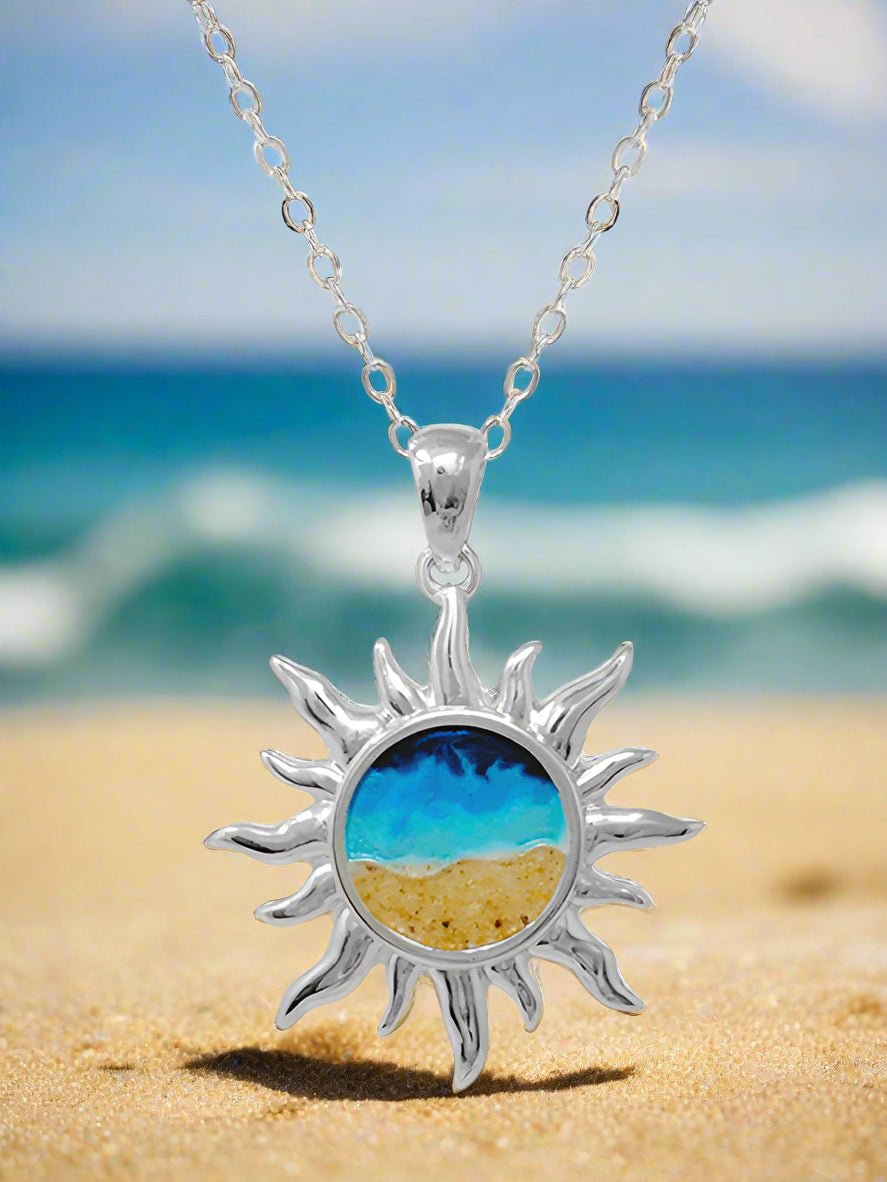 Sun-shaped pendant with beach scene design on a white background